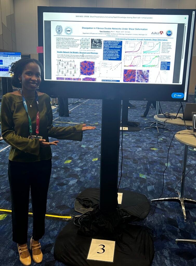 Rose in front of her poster stand presenting.